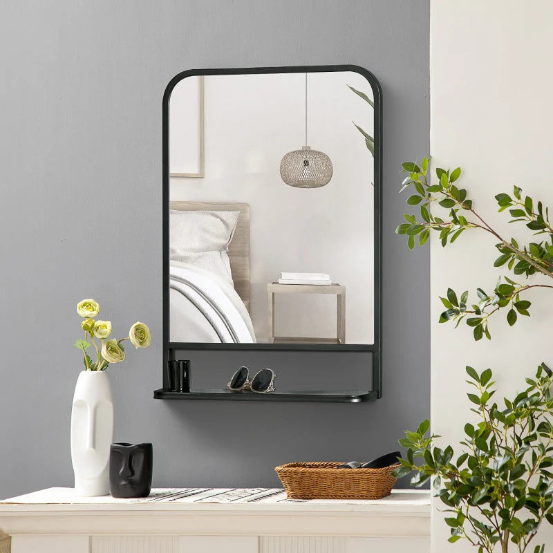 Espejo de pared negro con repisa decorando la entrada de un recibidor