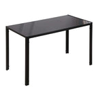 Mesa de comedor Shadó de cristal templado negro con patas de metal en un comedor moderno