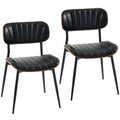 Set de dos sillas de comedor Falkenberg tapizadas en símil piel negro con patas de metal en un comedor moderno