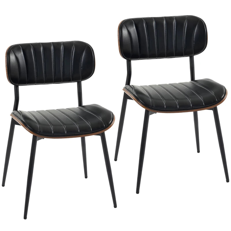 Set de dos sillas de comedor Falkenberg tapizadas en símil piel negro con patas de metal en un comedor moderno
