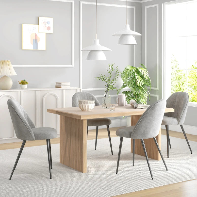 Sillas de comedor de terciopelo gris alrededor de una mesa moderna